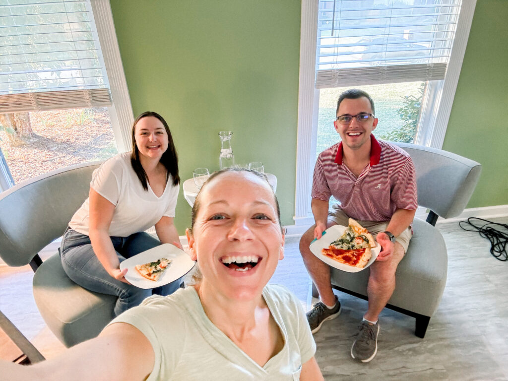 Couple re-living their wedding story during a Gallery Reveal Party with Rocheal Photography Group — champagne, laughter, and heirloom album design in Atlanta.